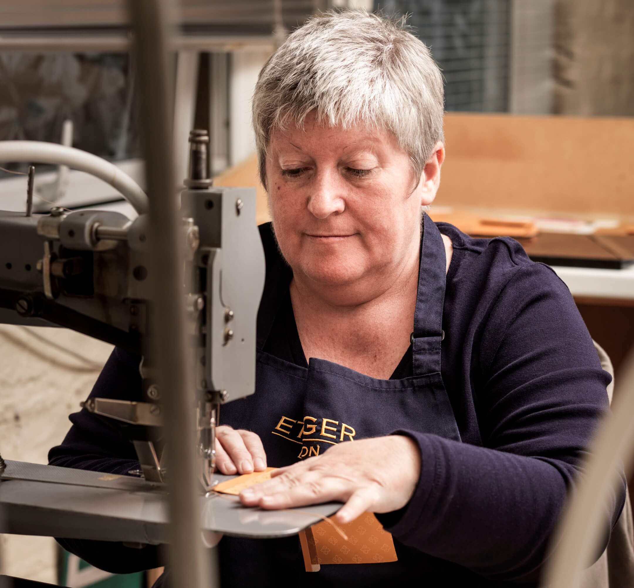 Factory worker, fashioning leather wallets and other leather goods of Ettinger