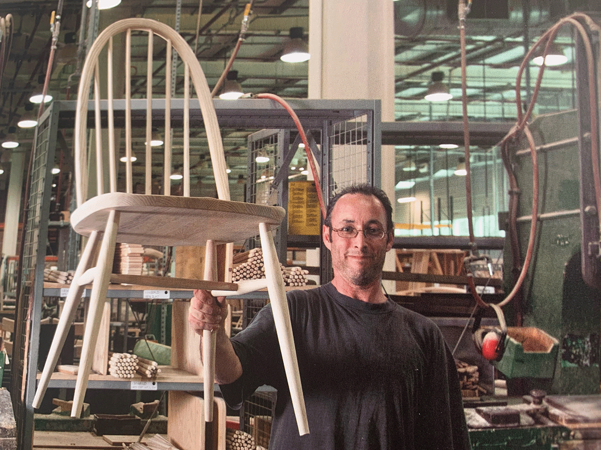Craftsman holding one Ercol classic chair